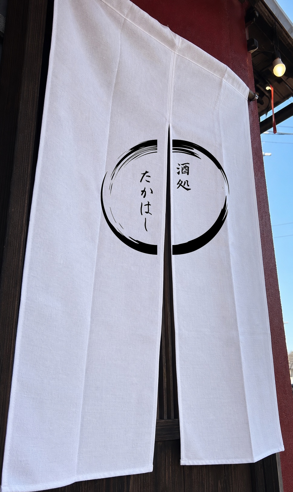 酒処たかはしのロゴが入った白いのれん