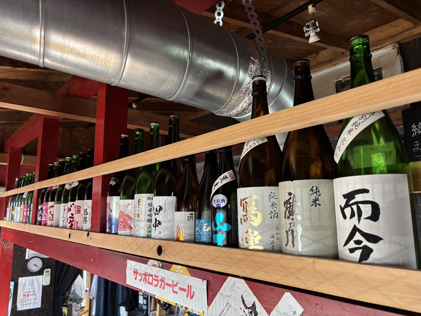 店内上部の棚に並ぶ日本酒の瓶